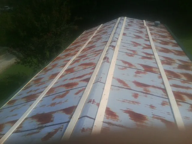 Rusted metal roof panels with new wood purlins before replacement — Storm Damage Roof Repair in South Gate by Roofing Brothers